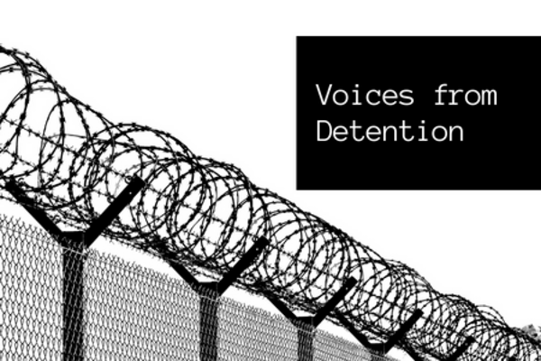 black and white image of barbed wire fencing, with a black square  on the top right that has white text that reads 'voices from detention'