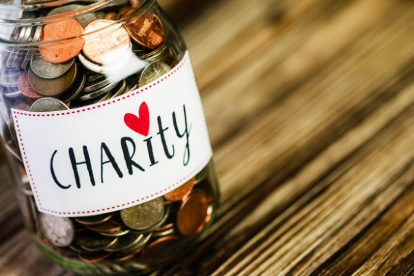 picture of a jar of money with a label saying 'charity' with a heart
