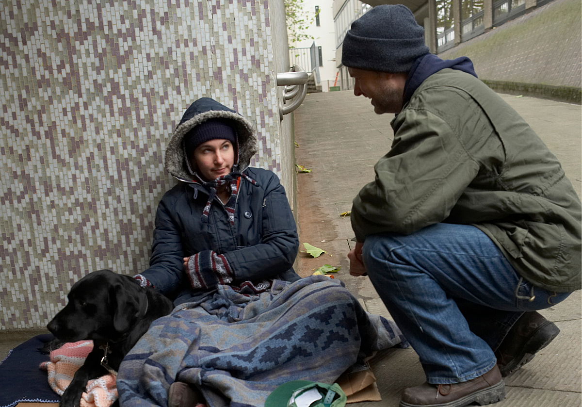 Man talking to homeless woman