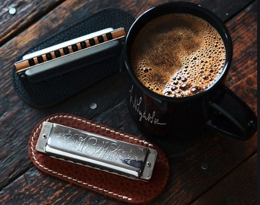 Cup of coffee and harmonicas on a table