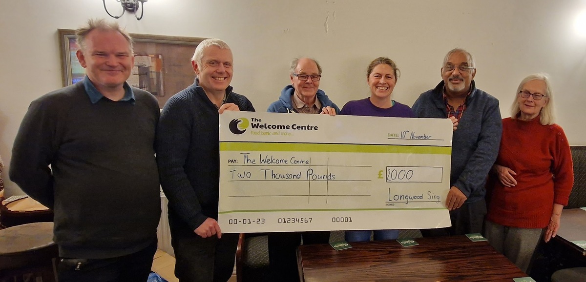Longwood Sing hand over cheque to The Welcome Centre