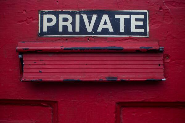 Red letter box with black sign reading PRIVATE