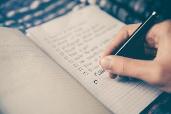 Close up of a hand writing a tick list